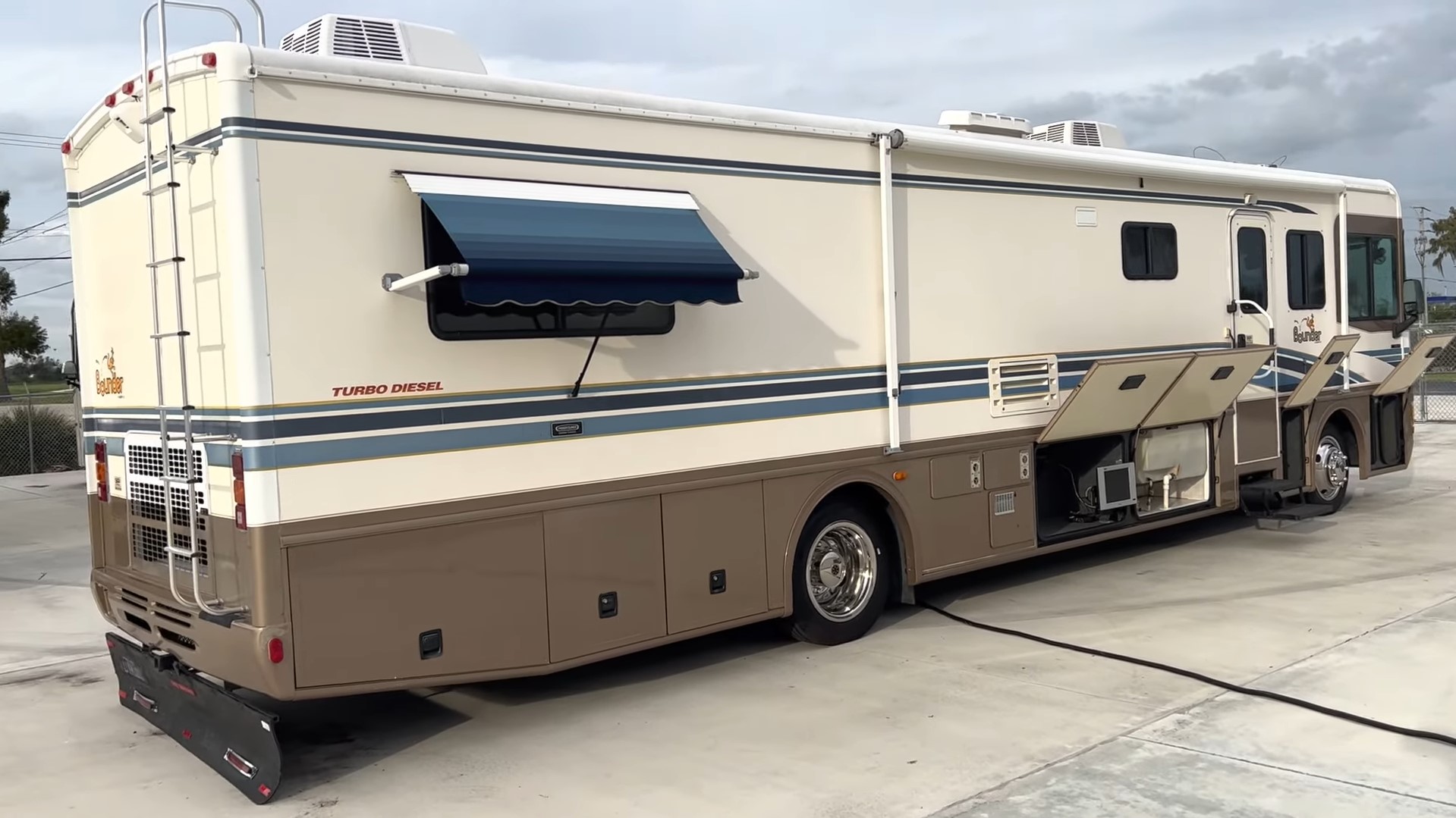 2000 Fleetwood Bounder 39Z — passenger side with patio awning and slide-out